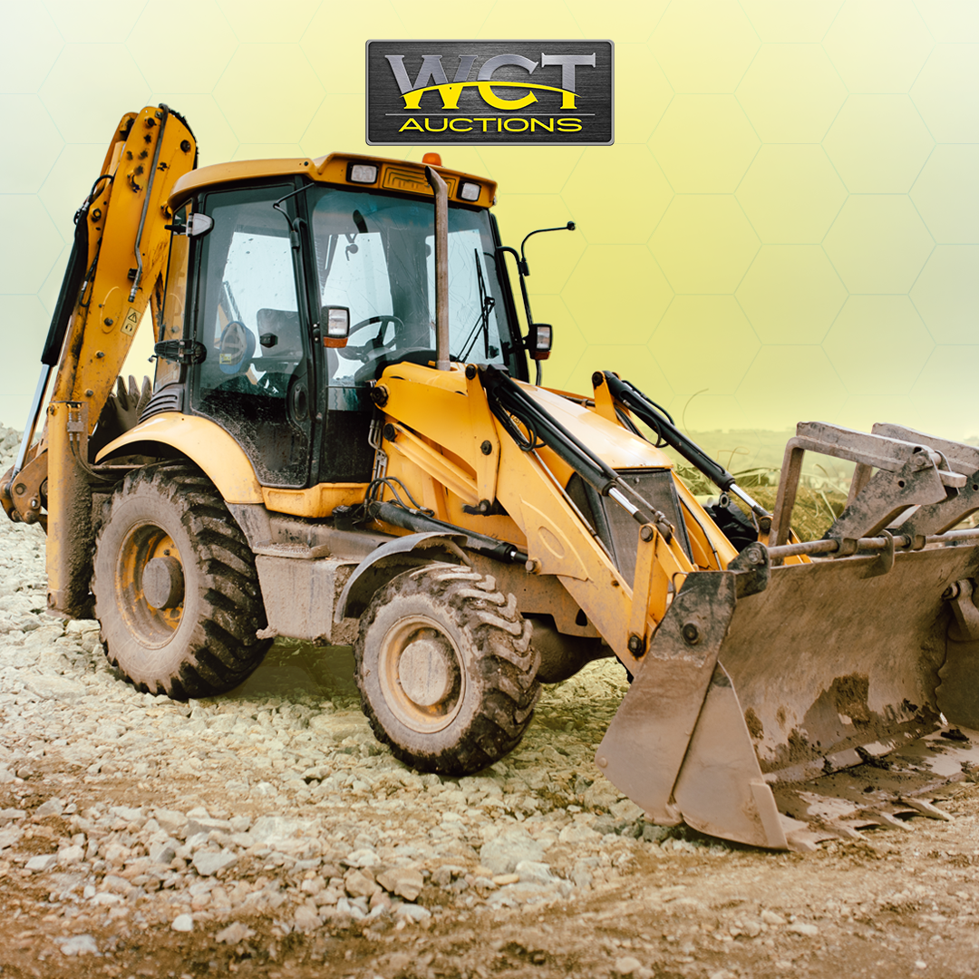 Yellow backhoe loader on a rocky site with WCT Auctions branding