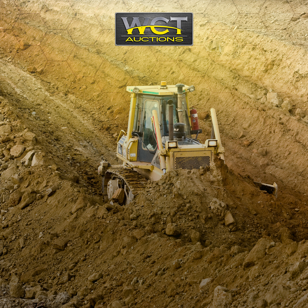 Used TLB working on a construction site with WCT Auctions branding